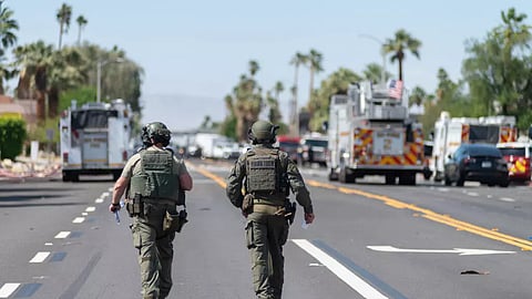 Two bomb disposal experts walk near the scene of a bomb blast that damaged a fertility clinic and killed one person, May 17, 2025, in Palm Springs, California.