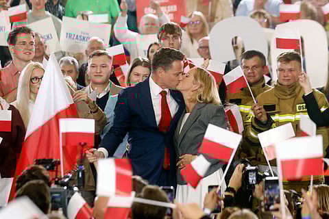 Rafal Trzaskowski, presidential candidate, Warsaw’s mayor and member of Poland’s ruling Civic Coalition party, kisses his wife on stage as he speaks to supporters after first exit polls following presidential elections are announced in Sandomierz.