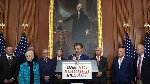 U.S. House Speaker Mike Johnson addresses the press at the Capitol on 22 May 2025, following the House’s narrow approval of President Donald Trump’s sweeping tax and spending legislation known as the "One, Big, Beautiful Bill" Act. Johnson stands at a podium bearing the bill’s name, flanked by Republican lawmakers and House Committee Chairmen, beneath a large portrait of George Washington and in front of American flags.