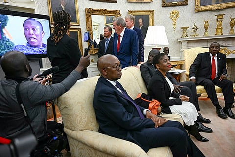 South African President Cyril Ramaphosa looks on as a controversial video is played during his meeting with U.S. President Donald Trump in the Oval Office of the White House in Washington, DC, on 21 May 2025. The video, part of a tense discussion, featured inflammatory claims about white Afrikaner farmers, which Trump has falsely labeled as victims of "genocide."