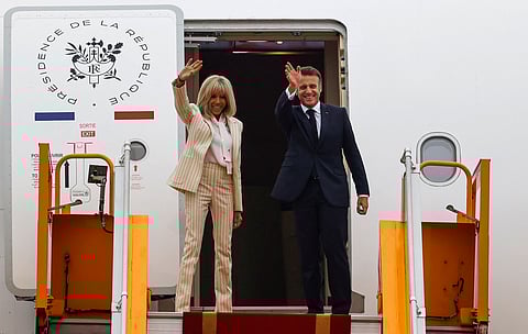 France's President Emmanuel Macron and his wife Brigitte Macron wave as they board their plane for departure following their visit to Vietnam at Noi Bai International Airport in Hanoi on 27 May 2025.