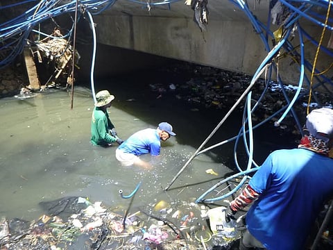Workers from Cainta LGU fixing entangled water pipes at a creek which block floating plastic debris.