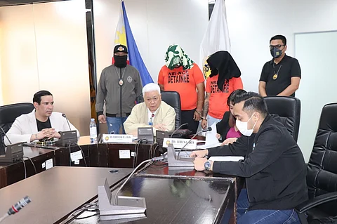 National Bureau of Investigation-National Capital Region chief Ferdinand Lavin (center) presents to the media the two suspected scammers targeting investors who were arrested during a raid by NBI operatives.