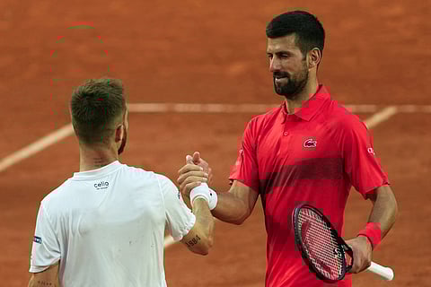 Serbia's Novak Djokovic (R) shakes hands with France's Corentin Moutet after defeating him during their men's singles match on day 5 of the French Open tennis tournament on Court Suzanne-Lenglen at the Roland-Garros Complex in Paris on 29 May 2025.