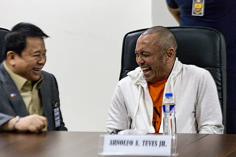 Former Negros Oriental Representative Arnie Teves in a rare light moment with one of his counsels Atty. Ferdinand Topacio (left) on the day he is presented at the National Bureau of Investigation headquarters on Friday, 30 May. Apprehended in Timor-Leste on 28 May after years in hiding, Teves faces multiple charges, including murder in connection with the 2023 assassination of former Governor Roel Degamo and 10 others, and the 2019 killings of three individuals. He was expelled from the House of Representatives in August 2023, and was later designated a terrorist by the Anti-Terrorism Council.