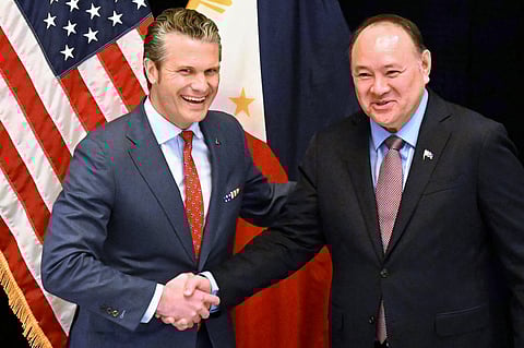 US Secretary of Defense Pete Hegseth (L) shakes hands with Philippines' Secretary of National Defense Gilberto Teodoro (R) before a bilateral meeting on the sidelines of the Shangri-La Dialogue Summit in Singapore on 30 May 2025.