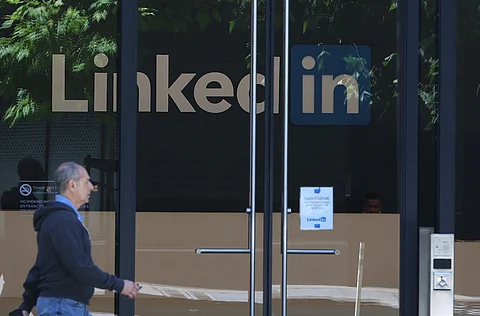 A PEDESTRIAN walks by a sign at a LinkedIn office on July 26, 2023 in San Francisco, California. LinkedIn announced plans to cut nearly 200 jobs at offices in the San Francisco Bay Area. The cuts follow 700 layoffs earlier in the year.