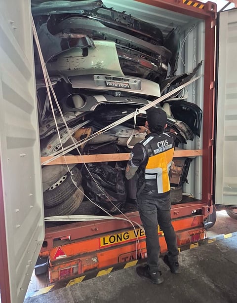 Personnel of the Bureau of Customs-Customs Intelligence and Investigation Services inspect one of the containers with imported second-hand car parts from the United States that arrived in the MICP on 5 June without proper import permits.