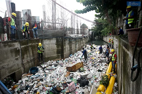 Metropolitan Manila Development Authority (MMDA) Workers manually and use backhoe to scoop out trash as part of the Bayanihan sa Estero, a program to clean waterways in Metro Manila as part of the agency's flood mitigating measures. Photo/Analy Labor