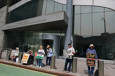 NEW YORK, NEW YORK - JUNE 13: People hold signs as they protest Israel outside the United States Mission to the United Nations building on June 13, 2025 in New York City. Ambassador Danny Danon issued a statement following Israel's strikes across Iran, which targeted nuclear facilities and killed senior nuclear scientists, top government officials, Iran’s highest-ranking military officer, and the head of the Islamic Revolutionary Guard Corps. Iran's Foreign Minister Abbas Araghchi has requested a meeting at the Security Council over the strikes.