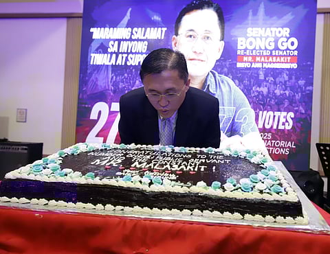 Senator Christopher “Bong” Go blows out candles during a post-election thanksgiving dinner in Manila, thanking supporters for his Senate victory.
