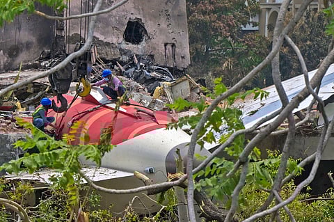 Workers removing aeroplane's tail from the wreckage after the June 12 Air India flight 171 crash, is pictured in a residential area near the airport in Ahmedabad on June 14, 2025. Investigators recovered a black box recorder on June 13 from the crash site of a London-bound passenger jet that ploughed into a residential area of India's Ahmedabad city, killing at least 265 people on board and on the ground.