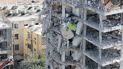 Through the rubble As Israeli rescuers search through the site of an Iranian missile strike that hit a residential building in Bat Yam near Tel Aviv and injured civilians, including six Filipinos, many Filipino workers caught in the Middle East crossfire between Israel and Iran claim they are in no immediate danger. (Inset) Ambassador Aileen Mendiola with Israel Foreign Minister Gideon Sa’ar at the missile impact site in Israel.