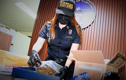 PERSONNEL of Bureau of Customs-NAIA Inter-Agency Drug Interdiction Task Group inspect the 'kush' discovered at the Central Mail Exchange Center in Pasay City.