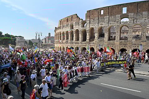 PEOPLE pass by the Colosseum as they take part in a national demonstration named '#StopRearmEU' against rearmament in Rome on 21 June 2025.