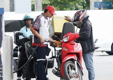Gas station personnel assist motorists at a pump in Brgy. UP Central along Commonwealth Avenue, Quezon City, on Monday. The Department of Energy warned that diesel prices could surge by up to ₱5 per liter starting Tuesday, driven by rising global oil prices. Following a meeting with the DOE, oil companies agreed to implement the hike in staggered installments to ease the burden on consumers.