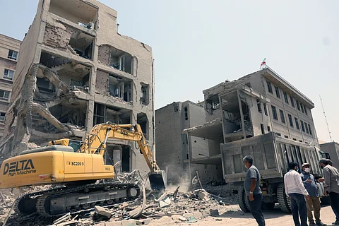 An excavator is used to clear the rubble in front of a building recently hit in Israeli strikes in Tehran on June 26, 2025, following a ceasefire with Israel that ended 12 days of fighting.