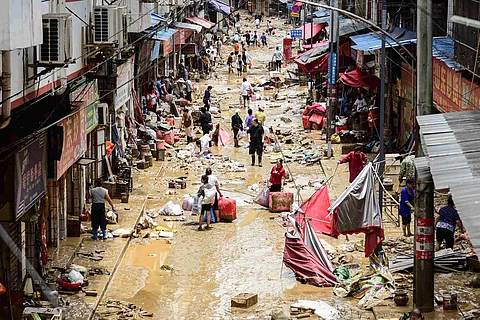 PEOPLE walk with their belongings at a flood-affected area in Congjiang, in southwestern China’s Guizhou province on June 25, 2025. Six people have died from floods inundating China's Guizhou province, state media said on June 26, 2025, after more than 80,000 people were driven from their homes this week.