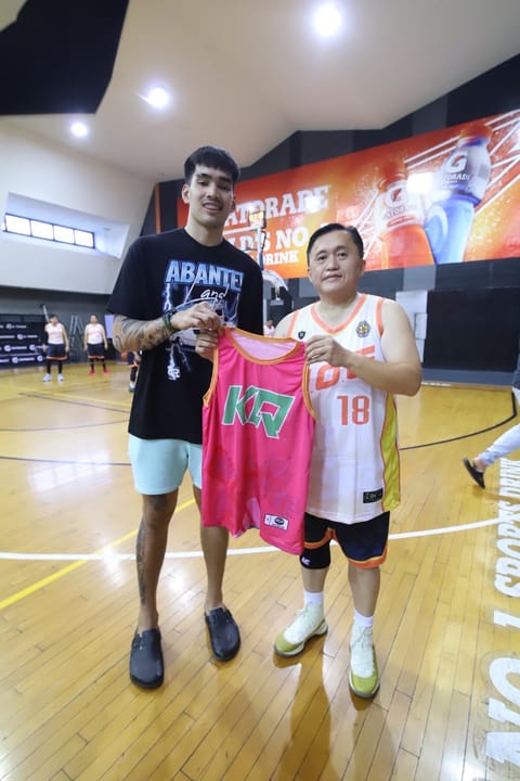 SENATOR Christopher ‘Bong’ Go (right) gets a KQ jersey from Kevin Quiambao at the sidelines of the Still Got Game 50 & Up event last Sunday.
