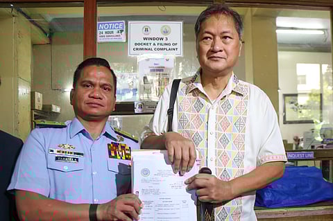 Philippine Coast Guard spokesperson Jay Tarriela shows a copy of his cyberlibel complaint against social media influencer Allan Rogando Sasot, also known as Sass Rogando Sasot, at the Office of the City Prosecutor in Manila on Friday. Tarriela is represented by his lawyers Antonio Laviña and Tim Calumpong.