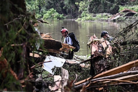 Members of a search and rescue team look for people near Camp Mystic, the site of where at least 20 girls went missing after flash flooding in Hunt, Texas, on July 5, 2025. Rescuers were on Saturday searching for more than 20 girls missing from a riverside summer camp in the US state of Texas, after torrential rains caused devastating flooding that killed at least 27 people -- with more rain on the way. "So far, we've evacuated over 850 uninjured people, eight injured people and have recovered 27 deceased fatalities at this time. Of these 27, 18 are adults, nine are children," said Kerr Country Sheriff Larry Leitha on July 5.
