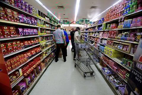 Shoppers’ look out Supermarket staff in Quezon City arrange products on shelves. A health expert says food warning labels help inform consumers and draw attention to potential hazards.