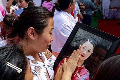 Kongbrailatpam Gitanjali Sharma, sister of plane crash victim Kongbrailatpam Nganthoi Sharma, a cabin crew member of the Air India flight AI171, mourns as she caresses her portrait during her funeral ceremony in Imphal on 22 June 2025. The London-bound jet burst into a fireball on 12 June, when it smashed down in Ahmedabad moments after takeoff. Grieving families held funerals in India for their relatives who were among at least 279 killed in one of the world's worst plane crashes in decades.