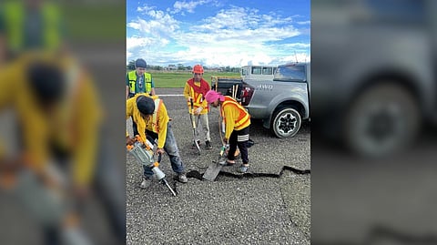 Airport personnel repair the potholes that were found along the runway of the Mactan-Cebu International Airport which caused significant flight delays.