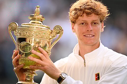 Italy's Jannik Sinner celebrates with the winner's trophy as he poses for pictures following his victory against Spain's Carlos Alcaraz at the end of their men's singles final tennis match on the fourteenth day of the 2025 Wimbledon Championships at The All England Lawn Tennis and Croquet Club in Wimbledon, southwest London, on July 13, 2025.