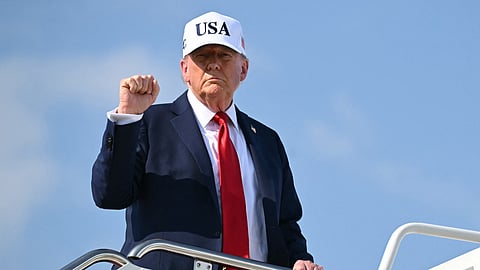 US President Donald Trump pumps his fist while boarding Air Force One at Joint Base Andrews in Maryland as he departs to deliver remarks at a Salute to America Celebration at the Iowa State Fairgrounds in Des Moines on July 3, 2025.