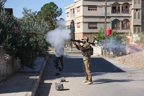 A Syrian security force member fires a shoulder-launched weapon amid clashes in the southern Sweida city on 16 July 2025.