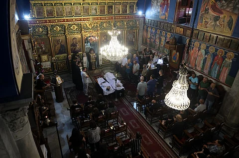 Christian Palestinian mourners attend the funeral ceremony of Saad Salameh and Foumia Ayyad, killed earlier in an Israeli strike that hit the Holy Family church in Gaza City, as Archbishop Alexios of the Saint Porphyrius Church leads the mass on July 17, 2025. An Israeli strike on Gaza's only Catholic church killed three people on July 17, the Latin Patriarchate of Jerusalem said, as Israel said it "never targets" religious sites and regretted any harm to civilians.