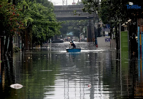 A man uses a small boat to cross floodwaters at N.S. Amoranto Street corner Araneta Avenue in Quezon City on Saturday, 19 July 2025, after continuous rains brought by the Habagat intensified by Severe Tropical Storm Crising.