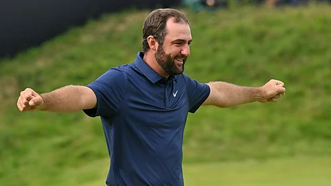 US golfer Scottie Scheffler celebrates on the 18th green after his victory in the 153rd Open Championship at Royal Portrush golf club in Northern Ireland on July 20, 2025. Scottie Scheffler romped to a magnificent four-shot victory to seal his first British Open title at Royal Portrush on Sunday, notching his fourth major success. The world number one eased to a three-under par final round of 68, finishing on 17-under for the tournament after shooting in the 60s on all four days.