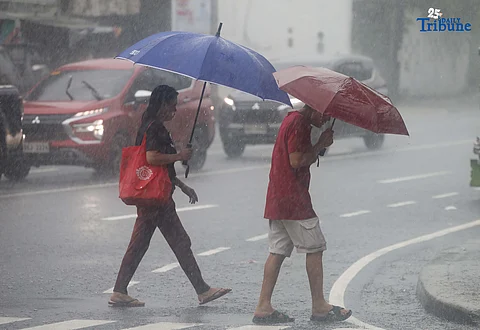 RAINY MONDAY: Pedestrians use umbrellas to shield themselves from the heavy downpour in Quezon City on Monday, July 21, 2025. While the newly formed low-pressure area (LPA) is not expected to directly affect the country, PAGASA said it has intensified the southwest monsoon or habagat, bringing more rain across the Philippines.