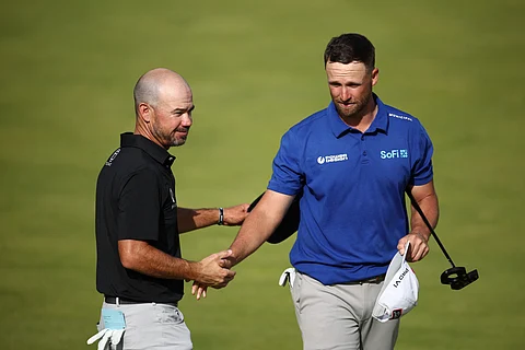 US golfer Brian Harman (L) and US golfer Wyndham Clark (R) shake hands on the 18th green on day four of the 153rd Open Championship at Royal Portrush golf club in Northern Ireland on July 20, 2025.
