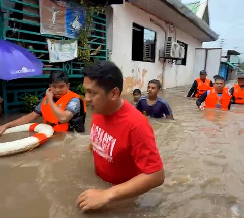 Rescuers and residents are having a hard time going through Barangay Maligaya in Floridablanca, Pampanga, due to the waist-deep flooding experienced after Tropical Storm Crising and heavy rainfall from the southwest monsoon dumped rainwater in the province.