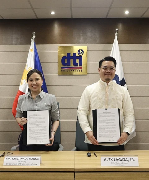 Trade Secretary Cristina Roque (left) and Rinna Co. Ltd. Global Business director Alex Lagata Jr. show the signed memorandum of understanding, for the firm to power the Department of Trade and Industry’s first artificial intelligence-powered assistant, signed last 14 July at the DTI office in Makati City.