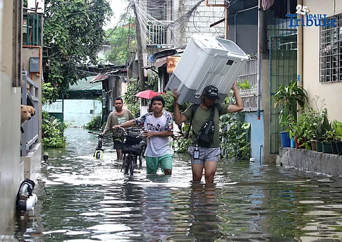 Residents in Barangay Rincon, Valenzuela City wade through flooded roads on July 22, 2025, as continuous rains submerge parts of the area. The southwest monsoon, or habagat, is expected to bring more moderate to heavy rainfall across Metro Manila, Luzon, and parts of the Visayas over the next three days, according to PAGASA.