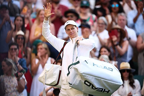 Italy's Jannik Sinner waves to the audience as he leaves the court following his victory over Serbia's Novak Djokovic at the end of their men's singles semi-final tennis match on the twelfth day of the 2025 Wimbledon Championships at The All England Lawn Tennis and Croquet Club in Wimbledon, southwest London, on July 11, 2025.