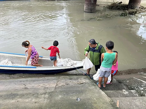 AboitizPower employees deliver relief packs via boat to typhoon affected areas of Bataan.