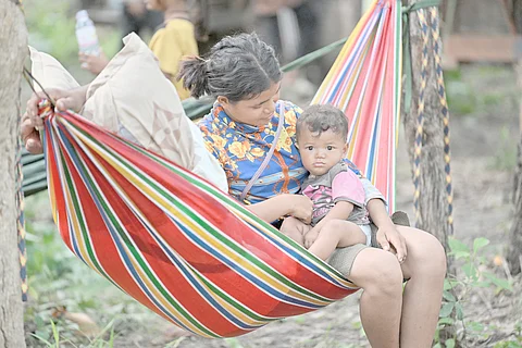 A MOTHER and her baby who fled their home near the Cambodia-Thailand border rest on a hammock on the grounds of a pagoda in Oddar Meanchey province on 25 July 2025.