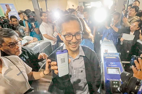 Department of Transportation Secretary Vince Dizon demonstrates the cashless payment option at the MRT-3 Ayala Station on Friday that is seen to improve the services of the mass transport system.