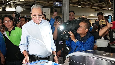 BSP Monetary Board Member Walter Wassmer tests the new tap-and-scan fare system at an MRT-3 station, marking the launch of digital payment options under the DOTr’s Automated Fare Collection System.