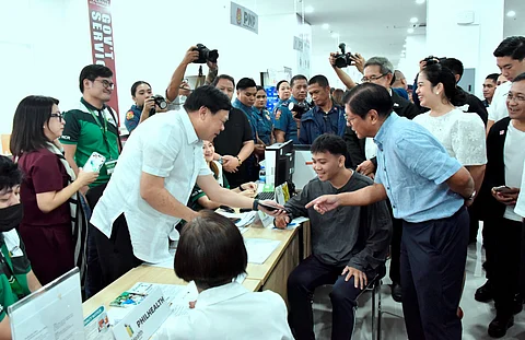 PRESIDENT Ferdinand Marcos Jr. (right) looks at the eGOVPH Serbisyo Hub and eGOVPH Super App being shown by PhilHealth acting president and CEO Dr. Edwin M. Mercado on the smartphone of the agency’s client during the launching of the public service platform at the Makabagong San Juan National Government Center in San Juan City on 21 July. The apps aim to make essential healthcare services easily accessible to the general public.