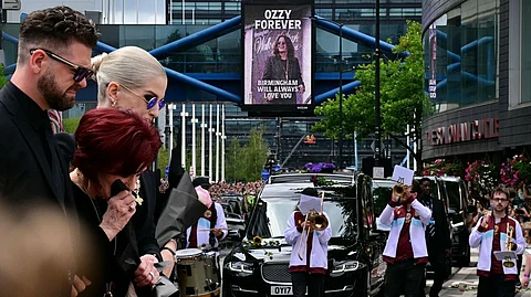 A CITY mourns its legend as the funeral cortege of Ozzy Osbourne passes through Birmingham landmarks. Sharon Osbourne leads heartfelt tribute at the Black Sabbath bench, surrounded by flowers and messages from fans.