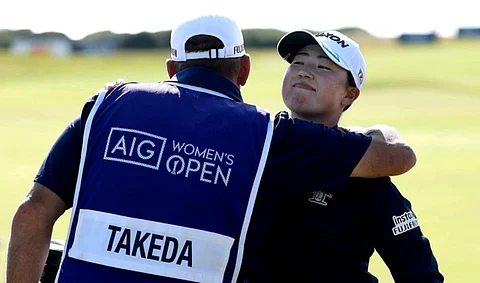RIO Takeda gets a hug from her caddie on the 18th green after the first round of the AIG Women’s Open 2025 at Royal Porthcawl Golf Club in Bridgen, Wales on Thursday.