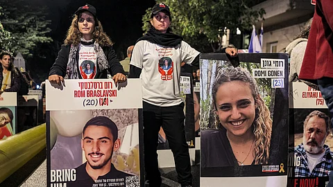 Protesters stand with portraits of Israeli hostages Rom Braslavski (20), Romi Gonen (23), and others during a demonstration by the families of the hostages taken captive in the Gaza Strip by Palestinian militants during the October 7, 2023 attacks, calling for action to release the hostages, outside the Israeli Prime Minister's residence in Azza (Gaza) Street in central Jerusalem on October 24, 2024 amid Israel's ongoing war with Hamas.