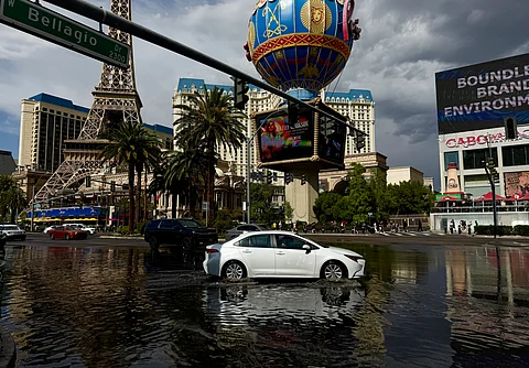 A car drives through standing water as sporadic heavy rain flooded areas of the Las Vegas Strip, Nevada on July 3, 2025.