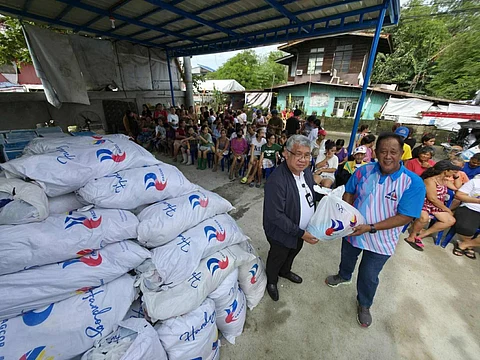 PAGCOR’s Joaquin Abejar hands over relief packages to Brgy. Igulot Chairman Eduardo Agapito for families affected by recent storms in Bocaue, Bulacan.
